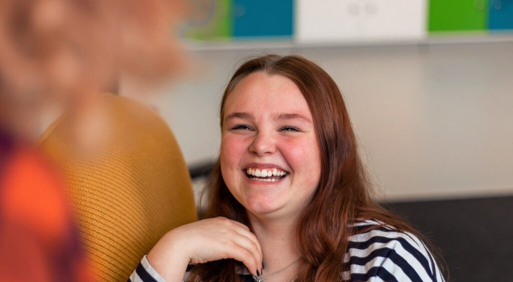 lastenohjaajaksi opiskelu suomen diakoniaopistossa kuvituskuvassa naurava nuori naisoletettu