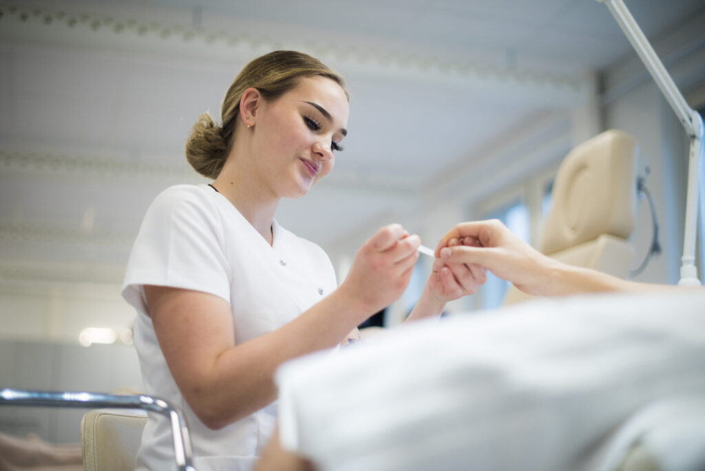 kosmetologiopiskelija tekee käsihoitoa kuvituskuva suomen diakoniaopisto